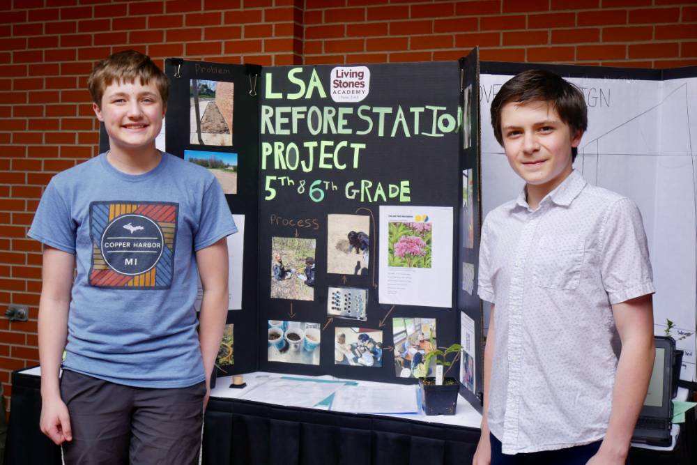 Student's stand in front of Living Stone Academy poster